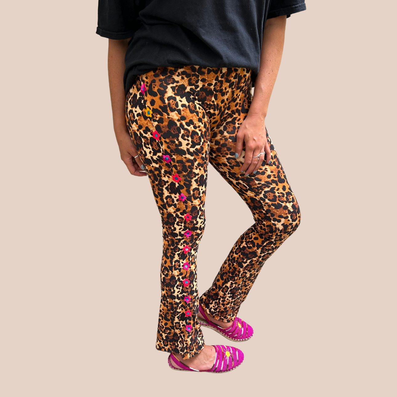 Brown leopard-print leggings in polyester and spandex with hand-embroidered pink flowers. Slightly flared at the ankle.