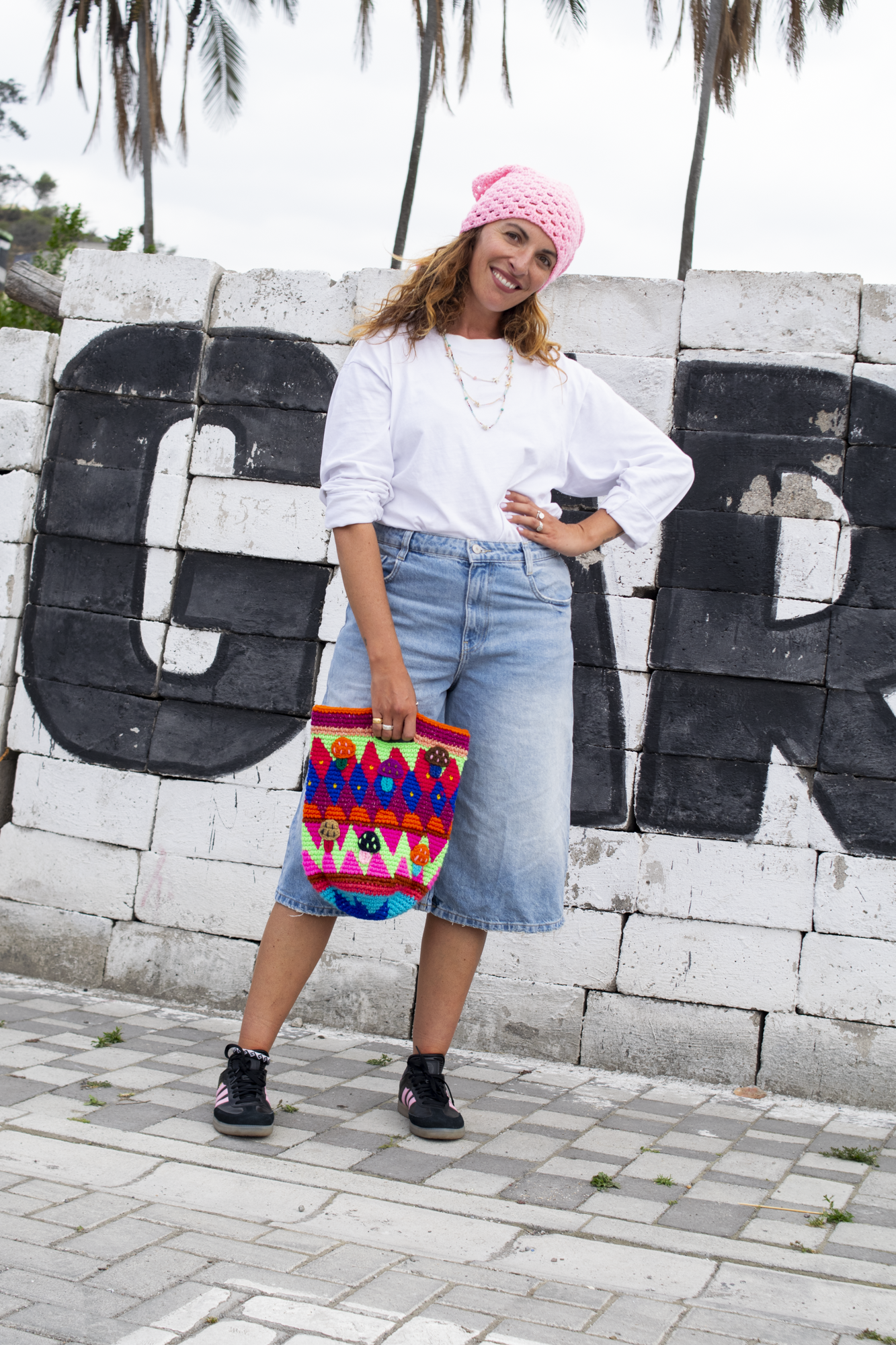 Bucket bag with integrated handles and multicolored mushroom patterns.