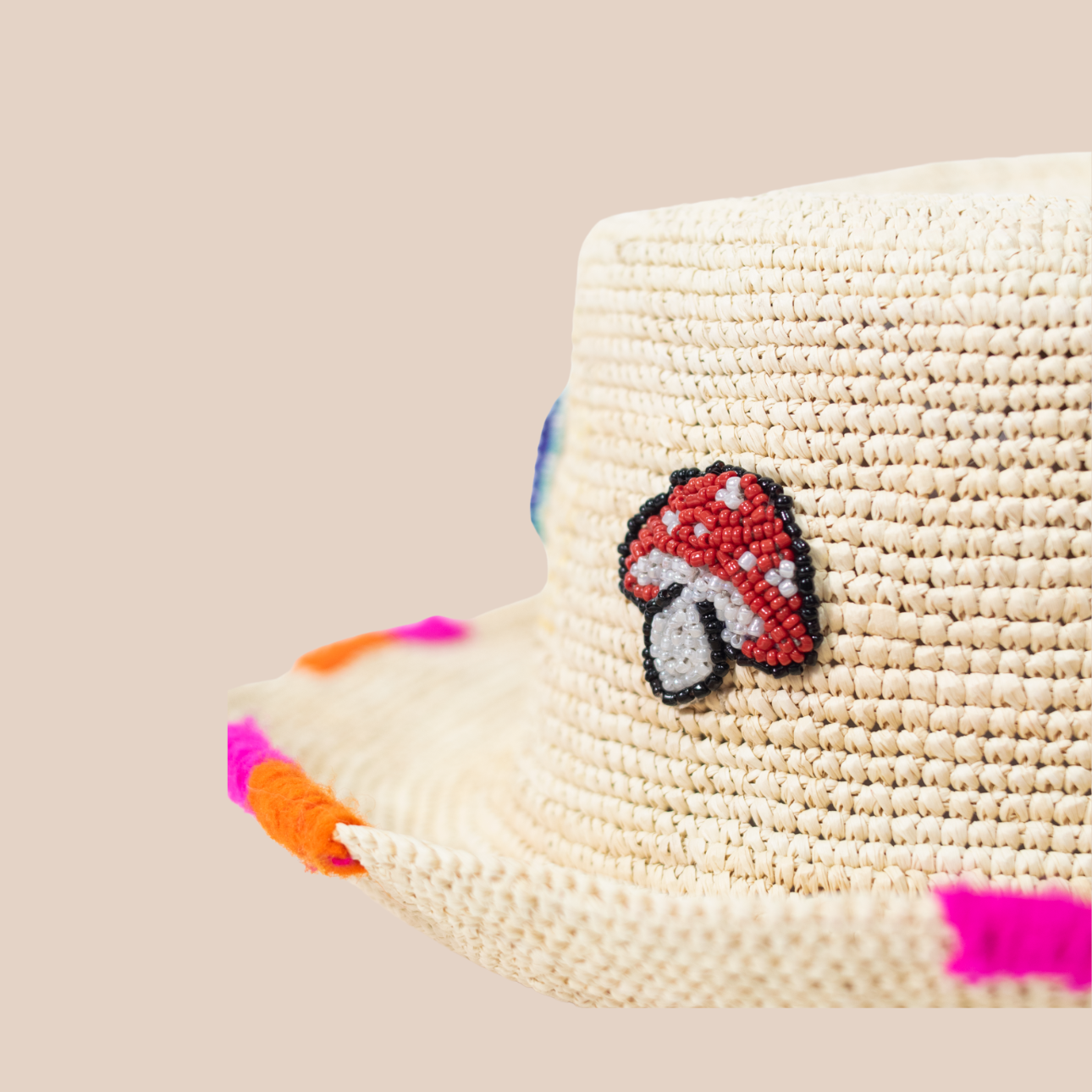Handmade hat crafted from untreated young palm fibers, adorned with beaded mushroom patterns.
