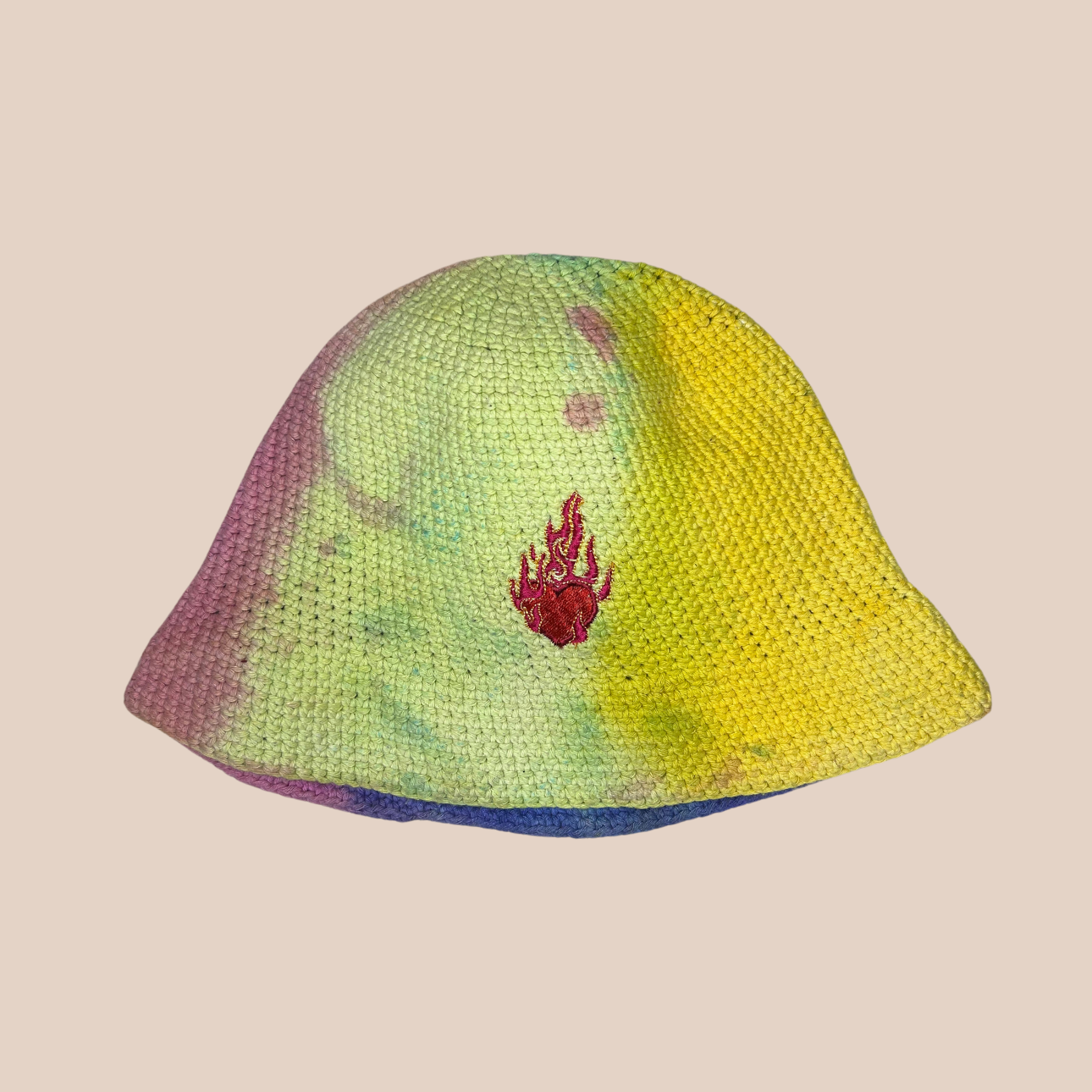 Un bucket hat crocheté en laine et acrylique, arborant des couleurs vives et audacieuses, motif coeur enflammé