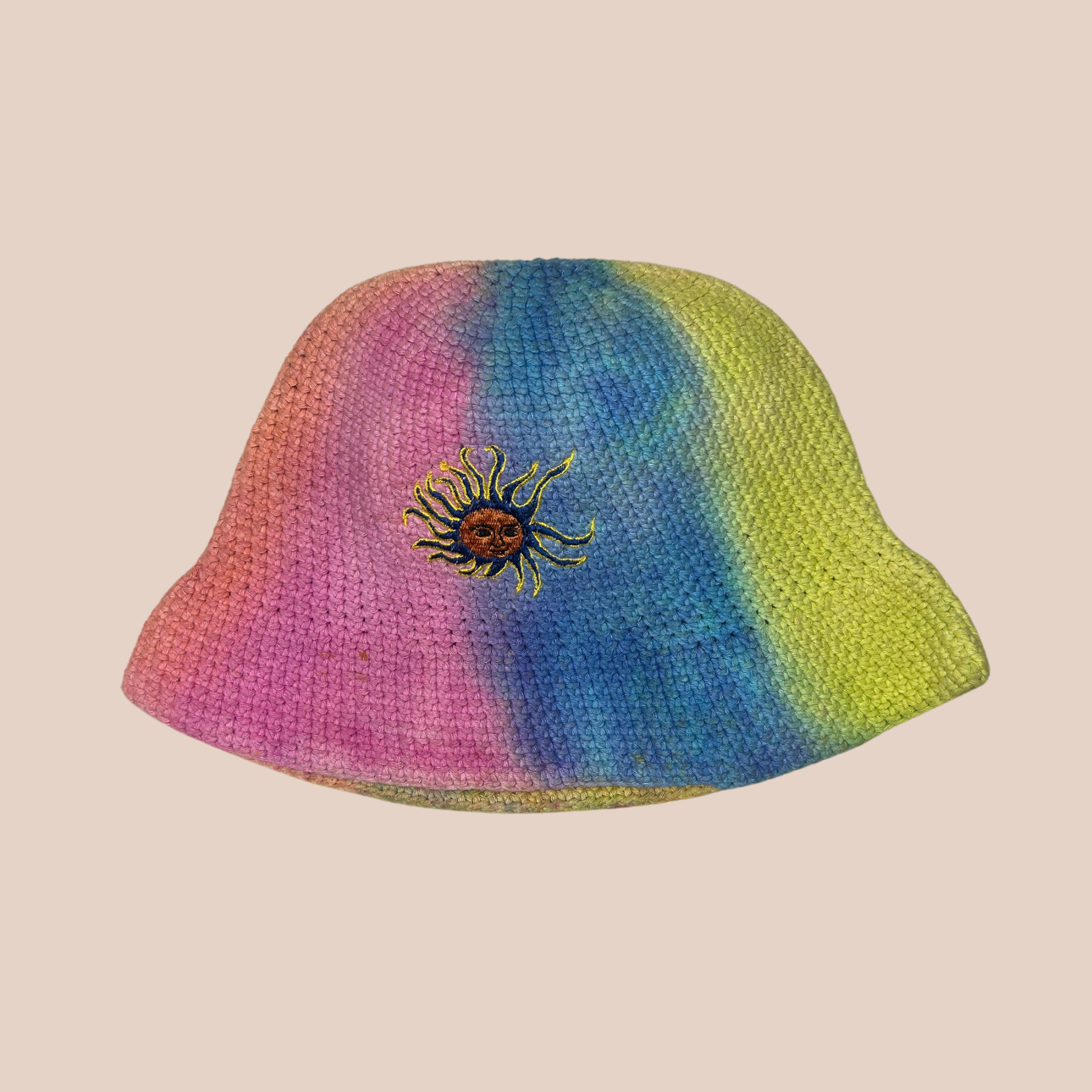 Un bucket hat crocheté en laine et acrylique, arborant des couleurs vives et audacieuses, motif soleil