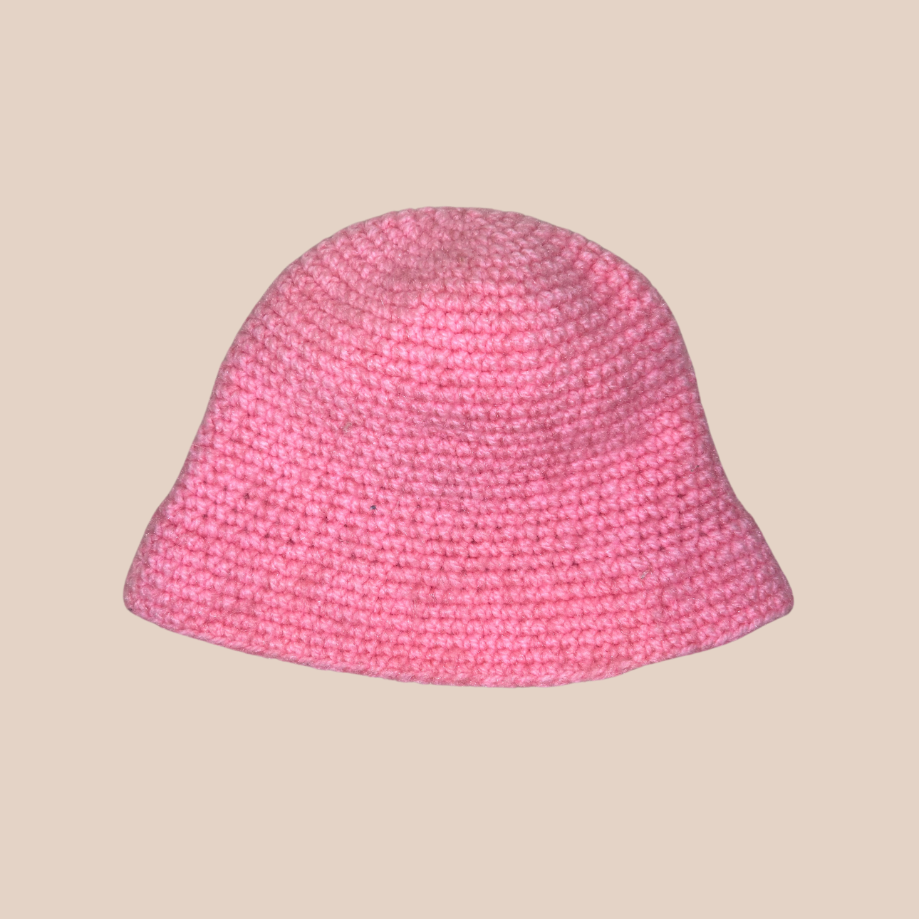 Un bucket hat crocheté en laine et acrylique, arborant un rose vif et audacieux