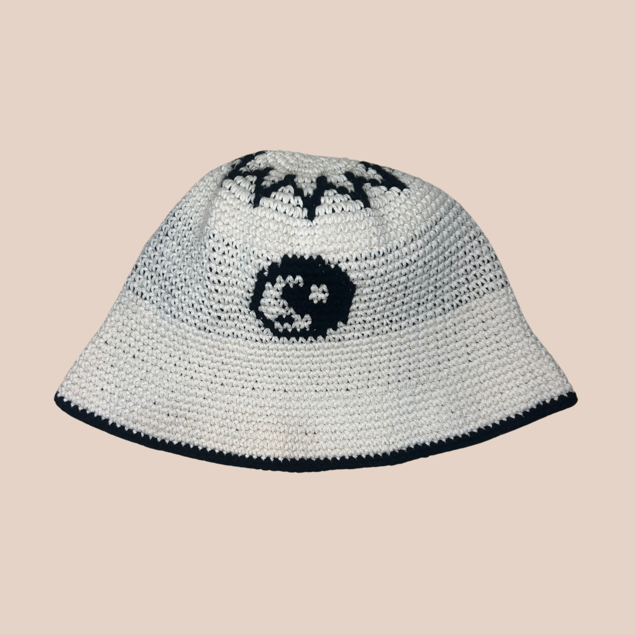 Un bucket hat crocheté en laine et acrylique, motif yin yang noir et blanc