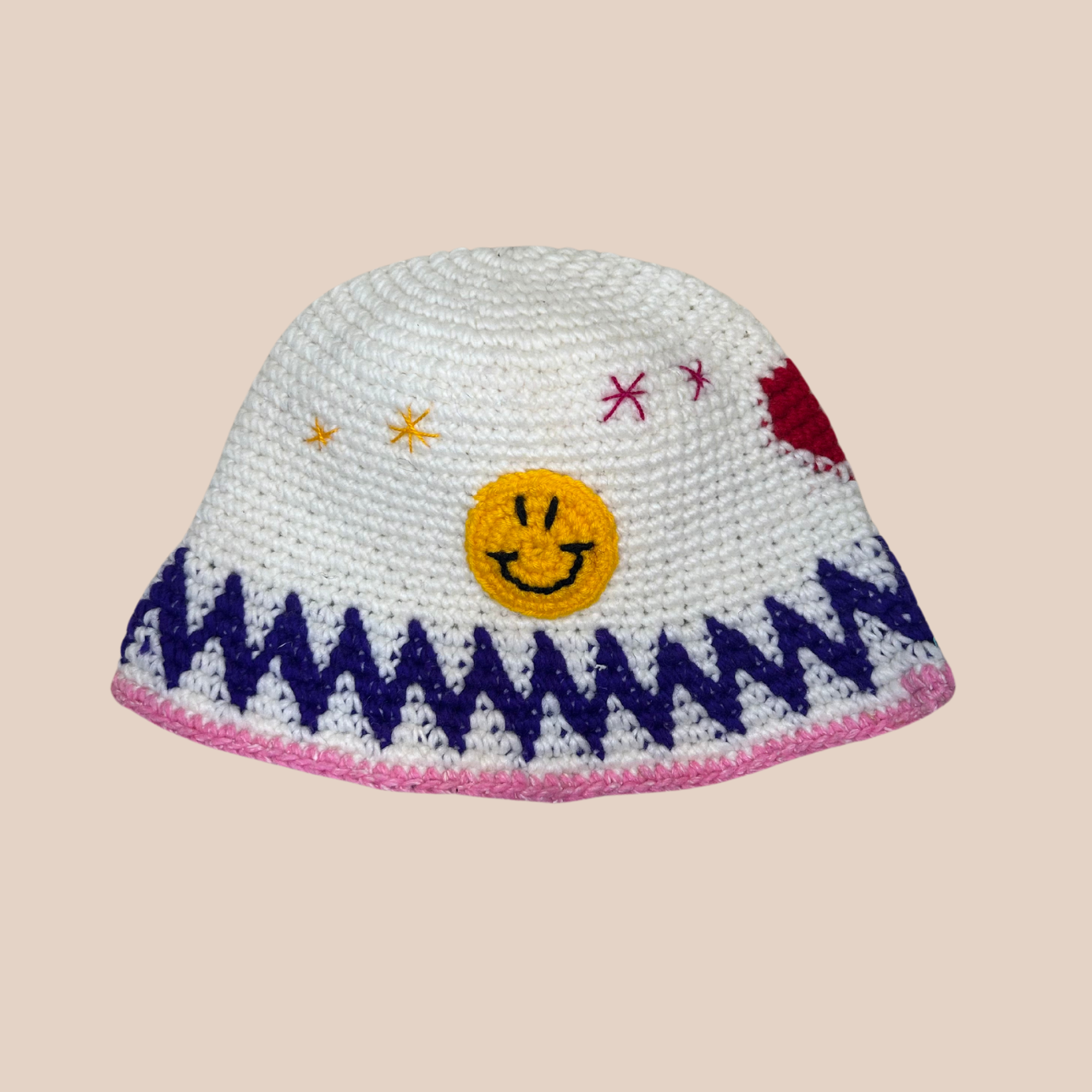 Un bucket hat crocheté en laine et acrylique, arborant des motifs aux couleurs vives et audacieuses