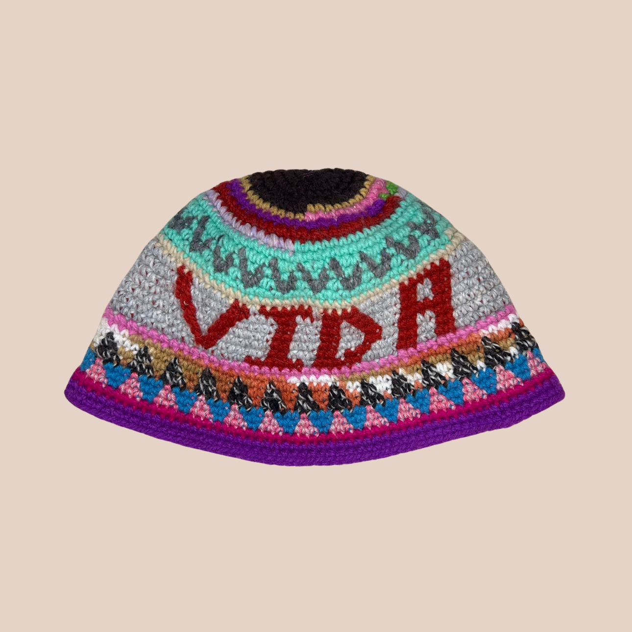 Image d'un bucket hat crocheté en laine et acrylique avec texte "vida" de Maison Badigo, arborant des couleurs vives et audacieuses
