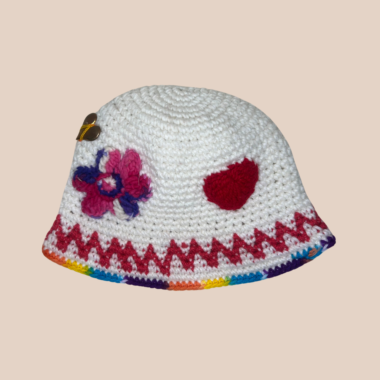 Image d'un bucket hat crocheté avec décoration coeur cousue main en laine et acrylique de Maison Badigo, arborant des couleurs vives et audacieuses 
