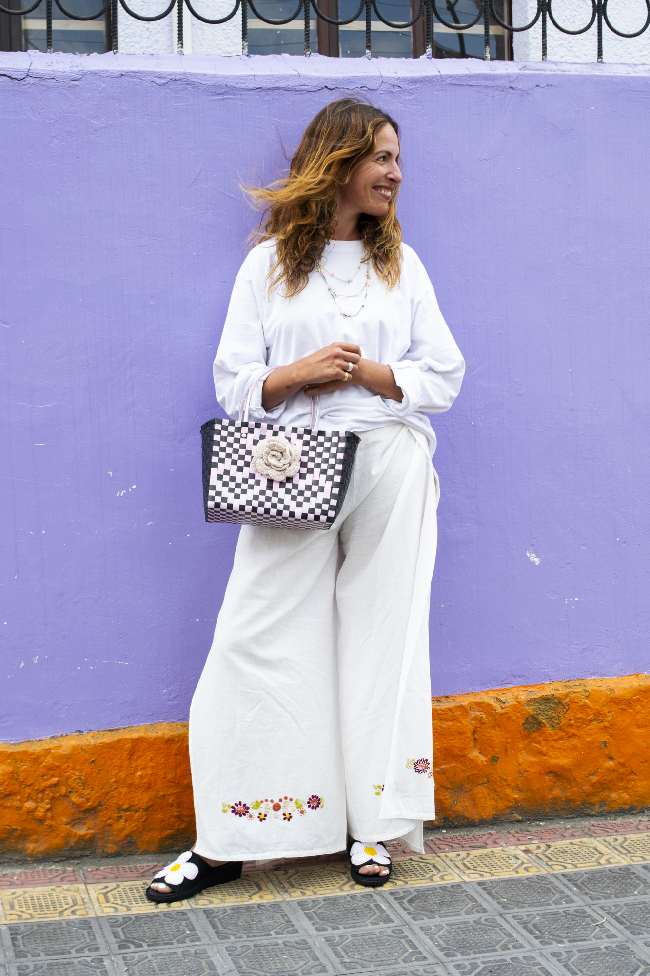 Handmade recycled plastic bag in pink, green, and white, featuring a large hand-crocheted sunflower.