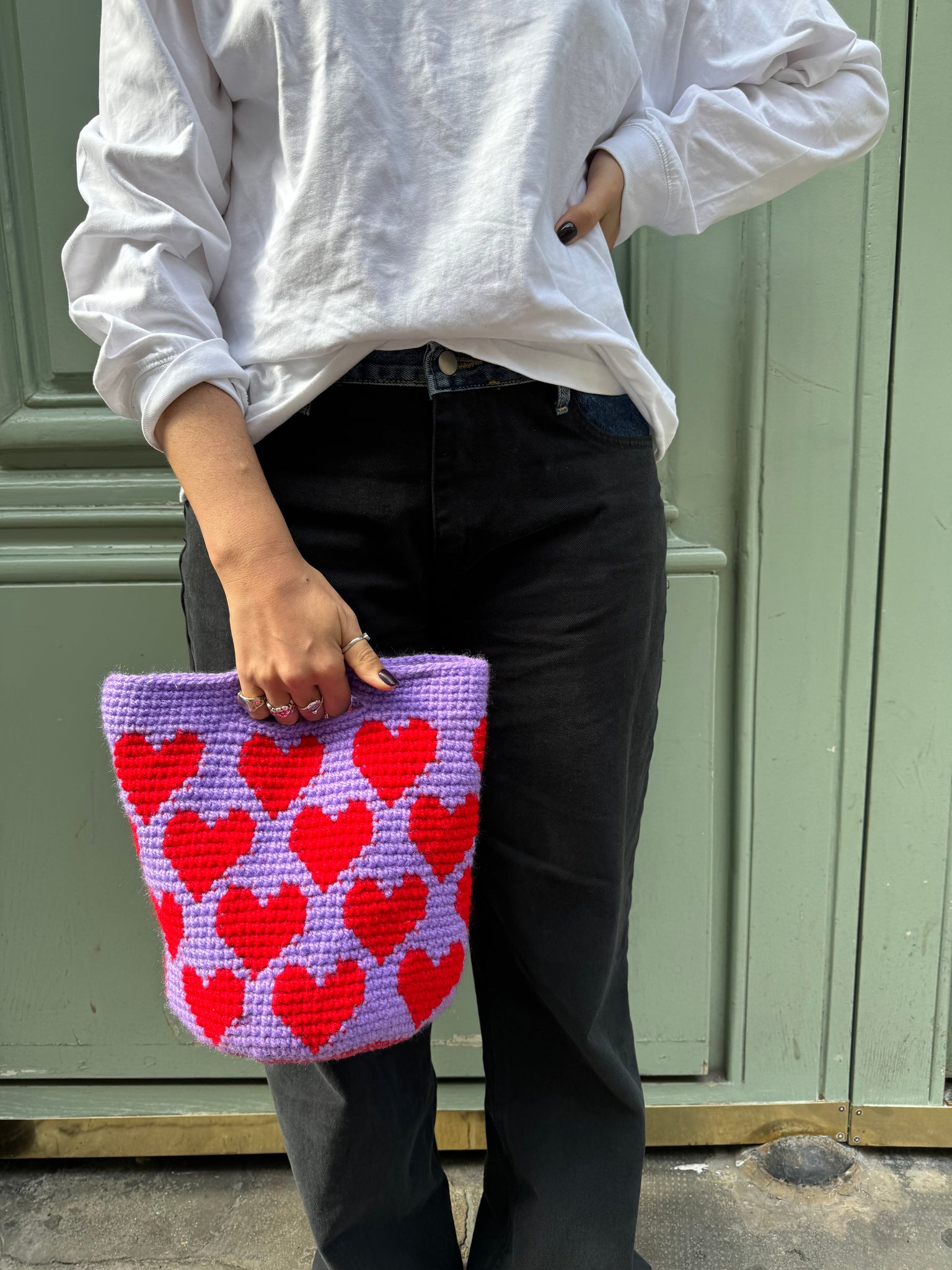 photo de lola portant un sac corazon lilas, motif coeurs rouge 