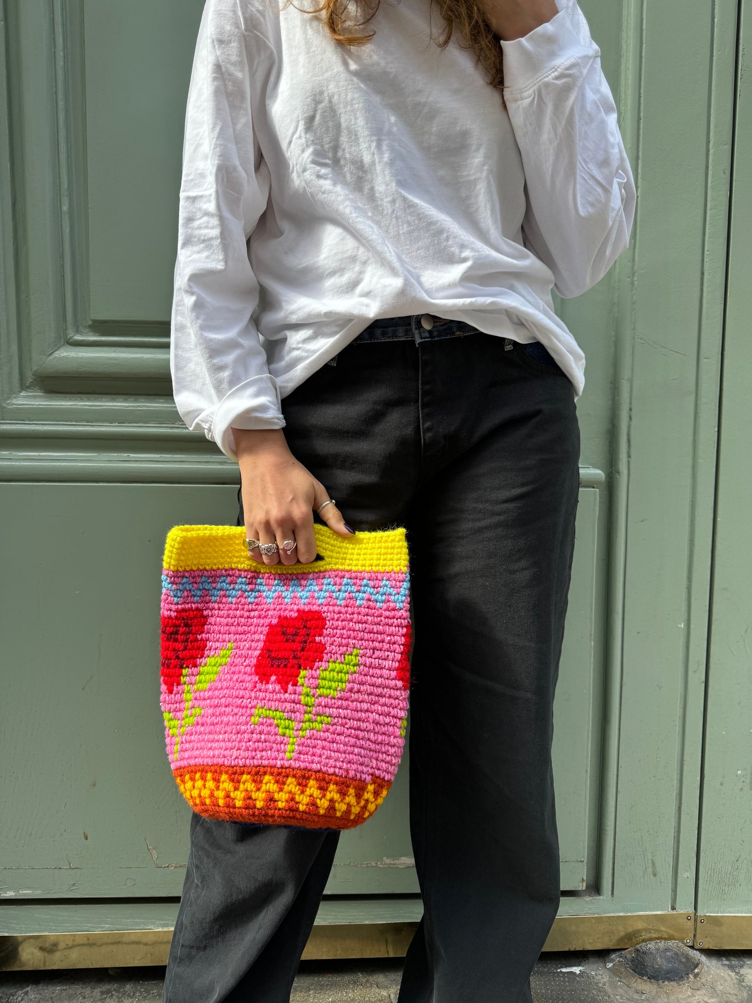photo de lola portant un sac rosa, motif fleurs arborant des couleurs vives et audacieuses