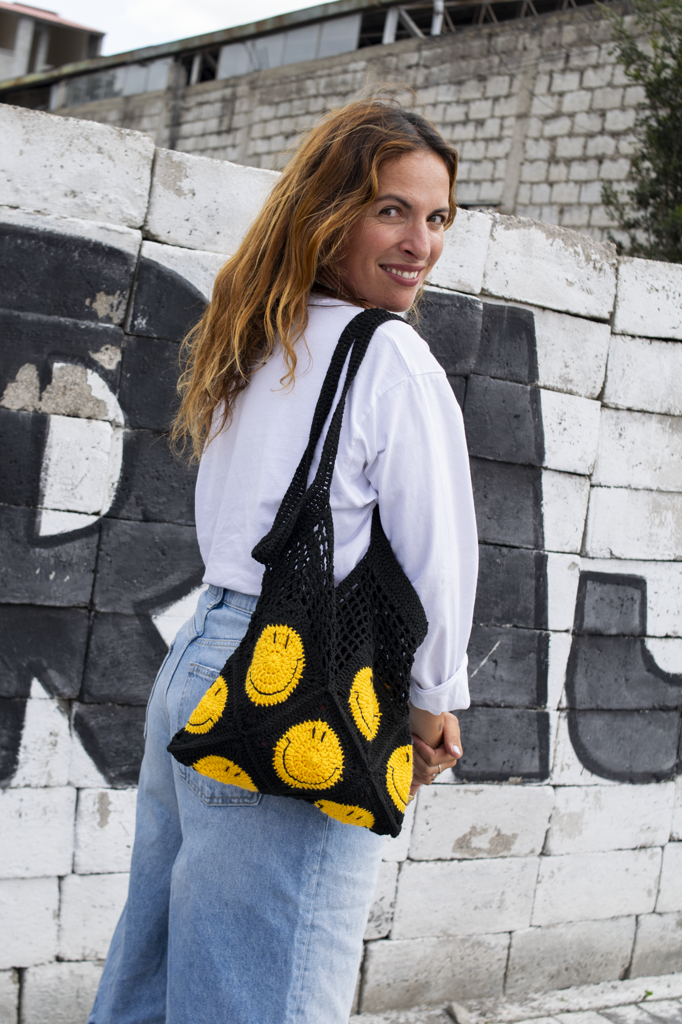 Hand-crocheted black cotton bag.
Two large cotton handles and yellow smiley patterns.