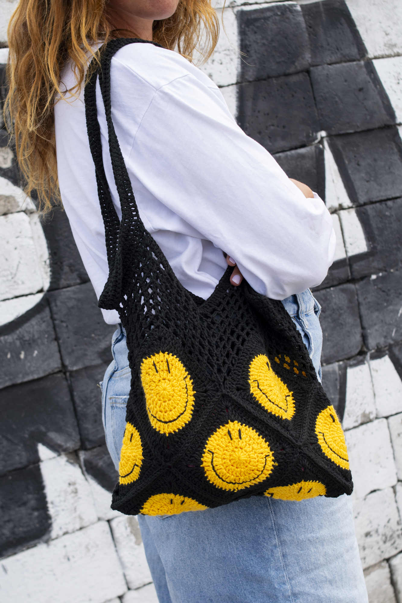 Hand-crocheted black cotton bag.
Two large cotton handles and yellow smiley patterns.