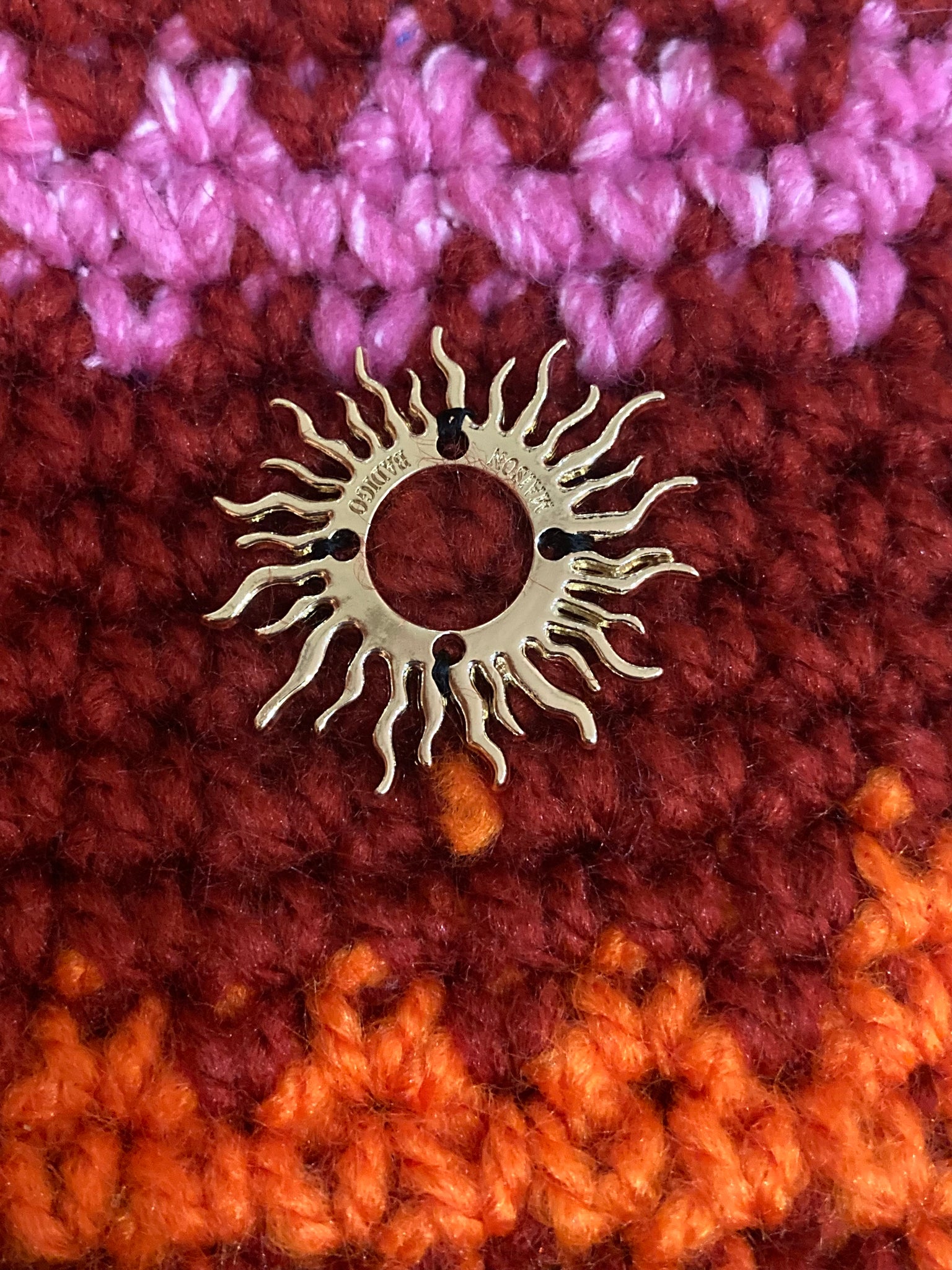 Image des mitaines de Maison Badigo, mitaines orange en laine crocheté avec medaillon soleil brodé